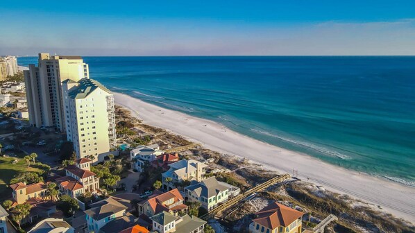 A coastal residential area with beachfront properties, a sandy beach, and a large hotel building. - 9 Rue Martine in Miramar Beach (Miramar Beach)