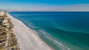 An aerial view of a beach with a long stretch of sandy shore, a few buildings, and a clear blue ocean. - 9 Rue Martine in Miramar Beach (Miramar Beach)