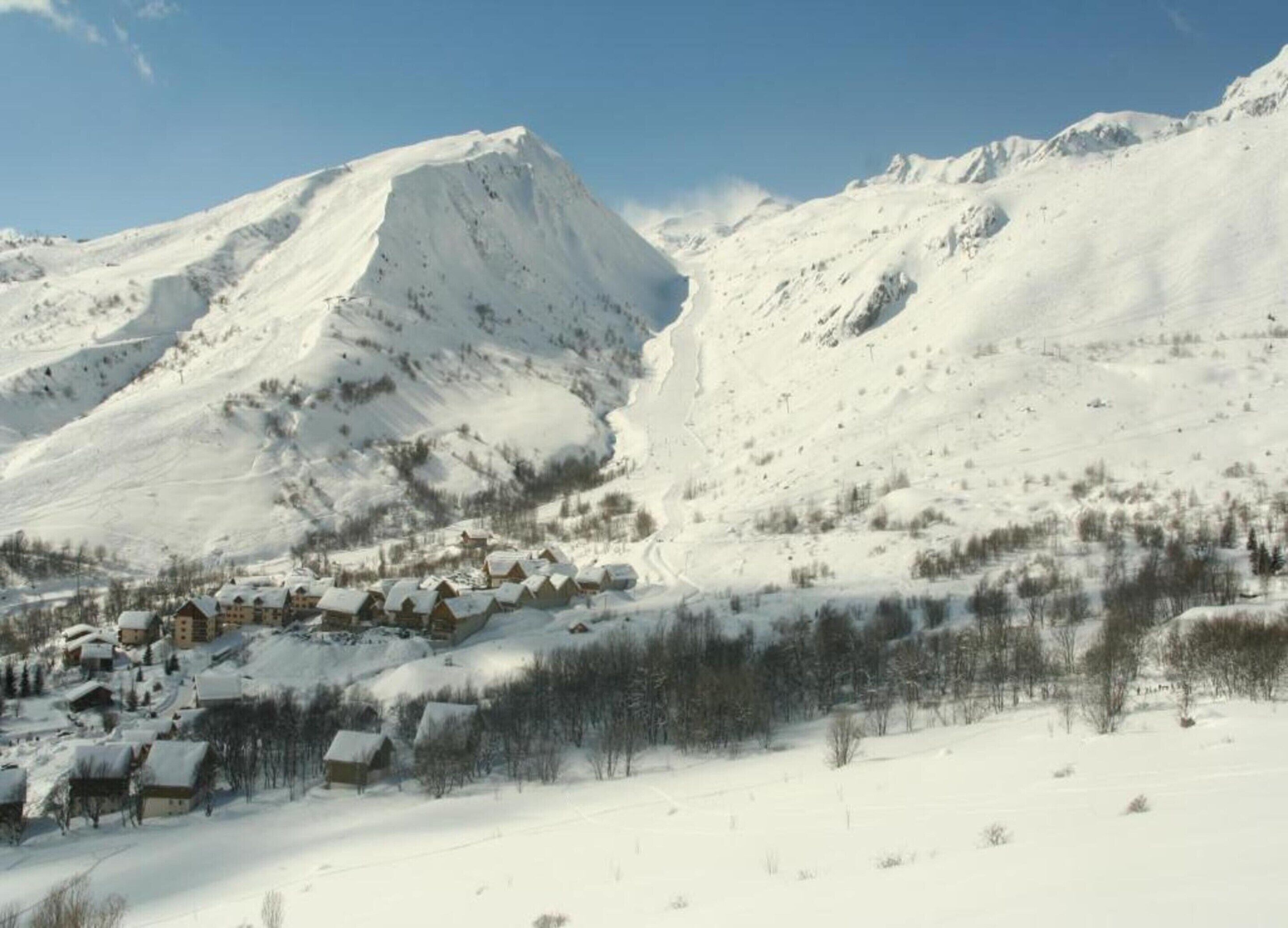 A snow-covered mountain with a village at its base.