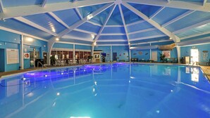 Ein Hallenbad mit hoher Decke und blauen Wänden.