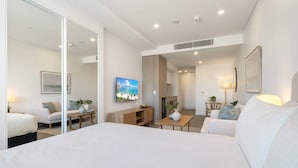 A modern hotel room with a large bed, a dining area, and a living space. - Stylish Studio Near Fremantle's Vibrant Spots (North Fremantle)