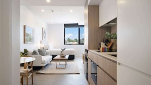 A modern kitchen with wooden cabinets and a built-in oven. - Stylish Studio Near Fremantle's Vibrant Spots (North Fremantle)