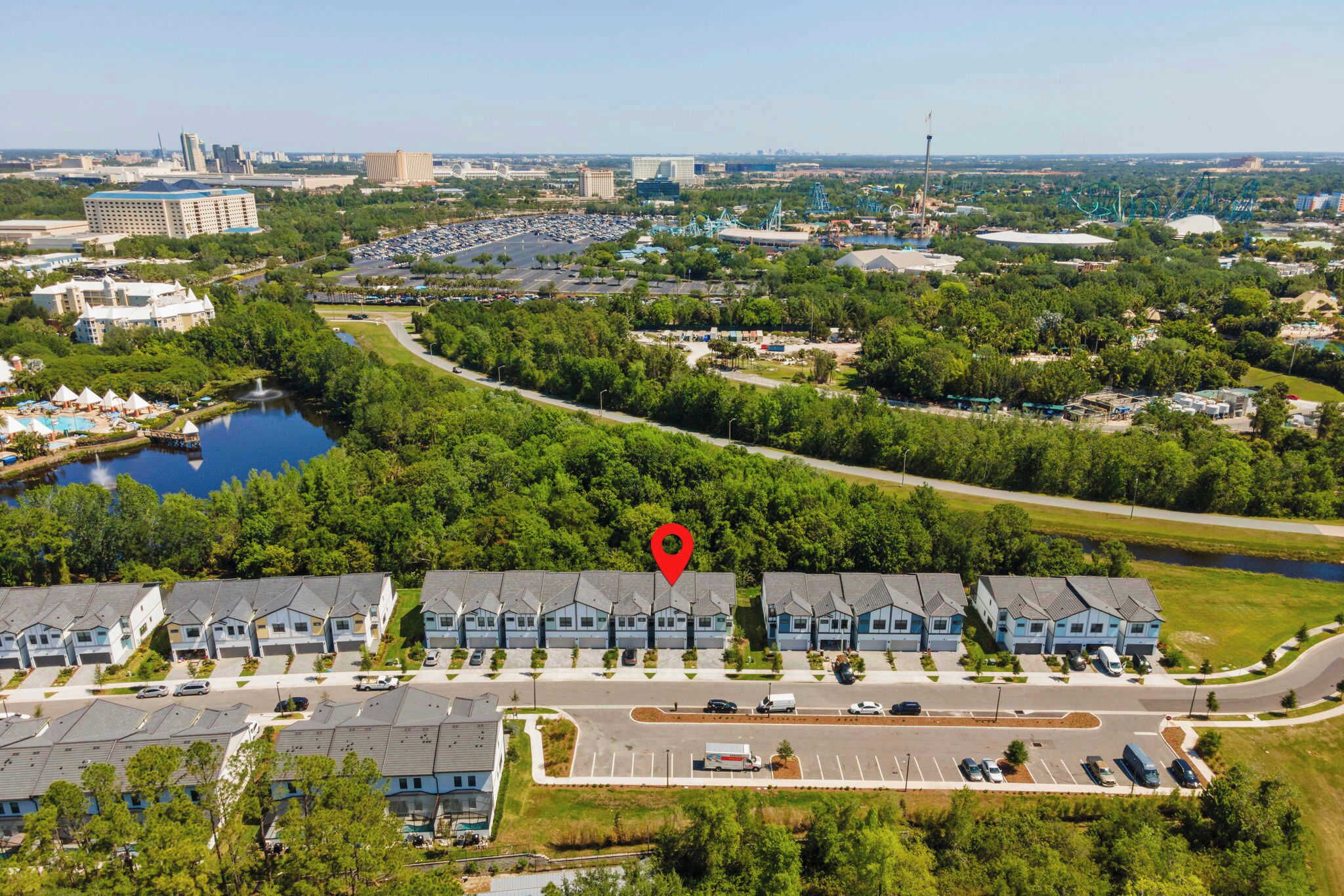 A residential area with multiple-story buildings, a parking lot, and a body of water.
