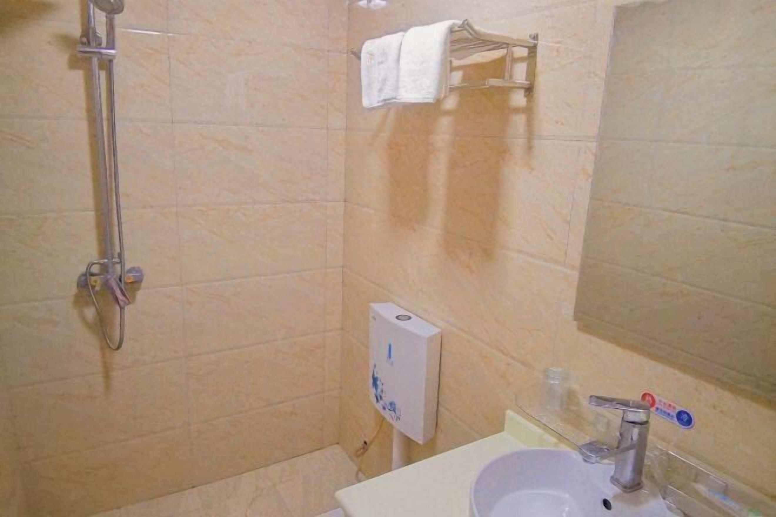 A bathroom with a shower, a sink, a mirror, and a towel rack.