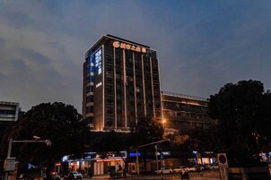 Un edificio de hotel alto con señalización iluminada durante la noche.