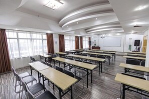 A conference room with multiple tables and chairs, a whiteboard, and a projector screen. - City Zhixin Boutique Hotel (Infrastructure Camp Central Hospital) (Xiangtan)