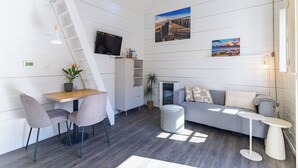 A modern interior with a loft-style bed, a dining area, a TV mounted on the wall, and a staircase. - Residence Domburg by Interhome (Domburg)
