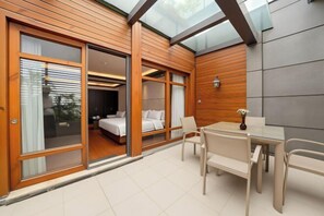 A modern hotel room with a glass door entrance, a bed, a small table, and a chair. - Chengdu YunSHEY Hotel (Chengdu)