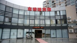 A modern building with a large glass facade and a red sign above the entrance. - Guxiangyi Hotel (Shanghai)