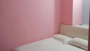 A small, single-bed room with pink walls and a white bed. - Guxiangyi Hotel (Shanghai)