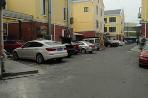 A street lined with parked cars and buildings. - Zhexin Business Hotel (Shanghai)