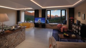 A modern living room with a large TV, a sofa, a coffee table, and a view of mountains through large windows. - Lanxiu Homestay (Lijiang)