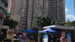 Un edificio residencial alto con múltiples balcones y un cielo despejado.