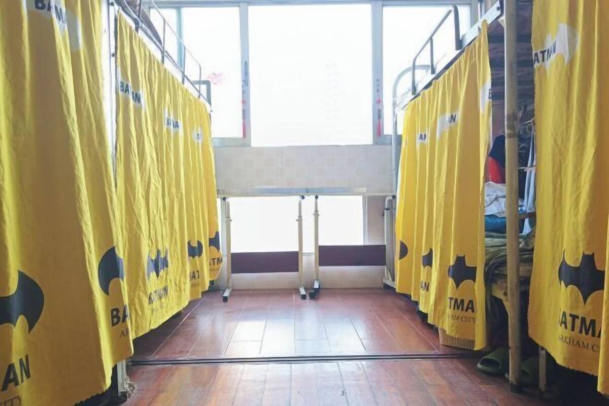 A room with yellow curtains, a window, and a wooden floor.