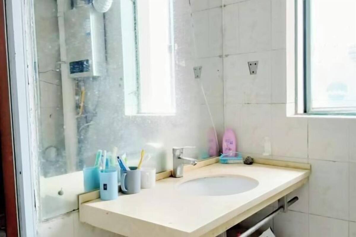 A bathroom with a sink, mirror, and toiletries.