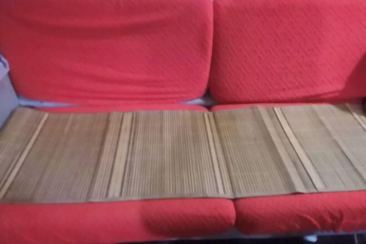A red sofa with a textured cushion.