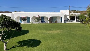 A white building with multiple arched doorways and a flat roof. - Villa Omega in Kokkali, Leros (Kokkali)