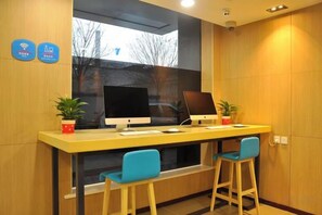 A reception desk with two computer monitors, a keyboard, and a mouse. There are two chairs and two potted plants. - Jingtie Business Hotel (Taiyuan Station Xi Square Subway Station) (Taiyuan)