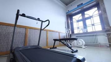 Ein Fitnessstudio mit Laufband, Trainingsgeräten und einem großen Fenster mit Blick.