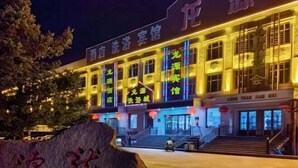 Ein Hotel mit mehreren Stockwerken und beleuchteter Beschilderung.