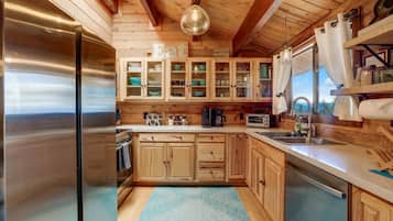 Una cocina con armarios de madera, un refrigerador de acero inoxidable y una alfombra azul.