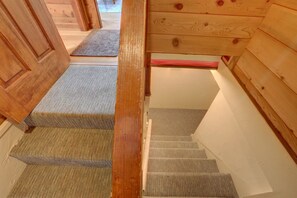 A wooden staircase with carpeted steps leading to a landing.