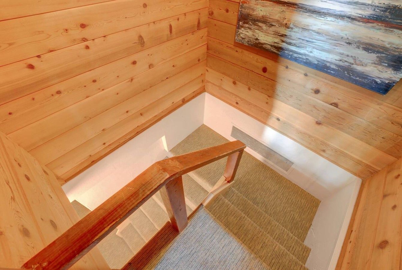 A wooden interior with a wooden staircase leading to a lower level.