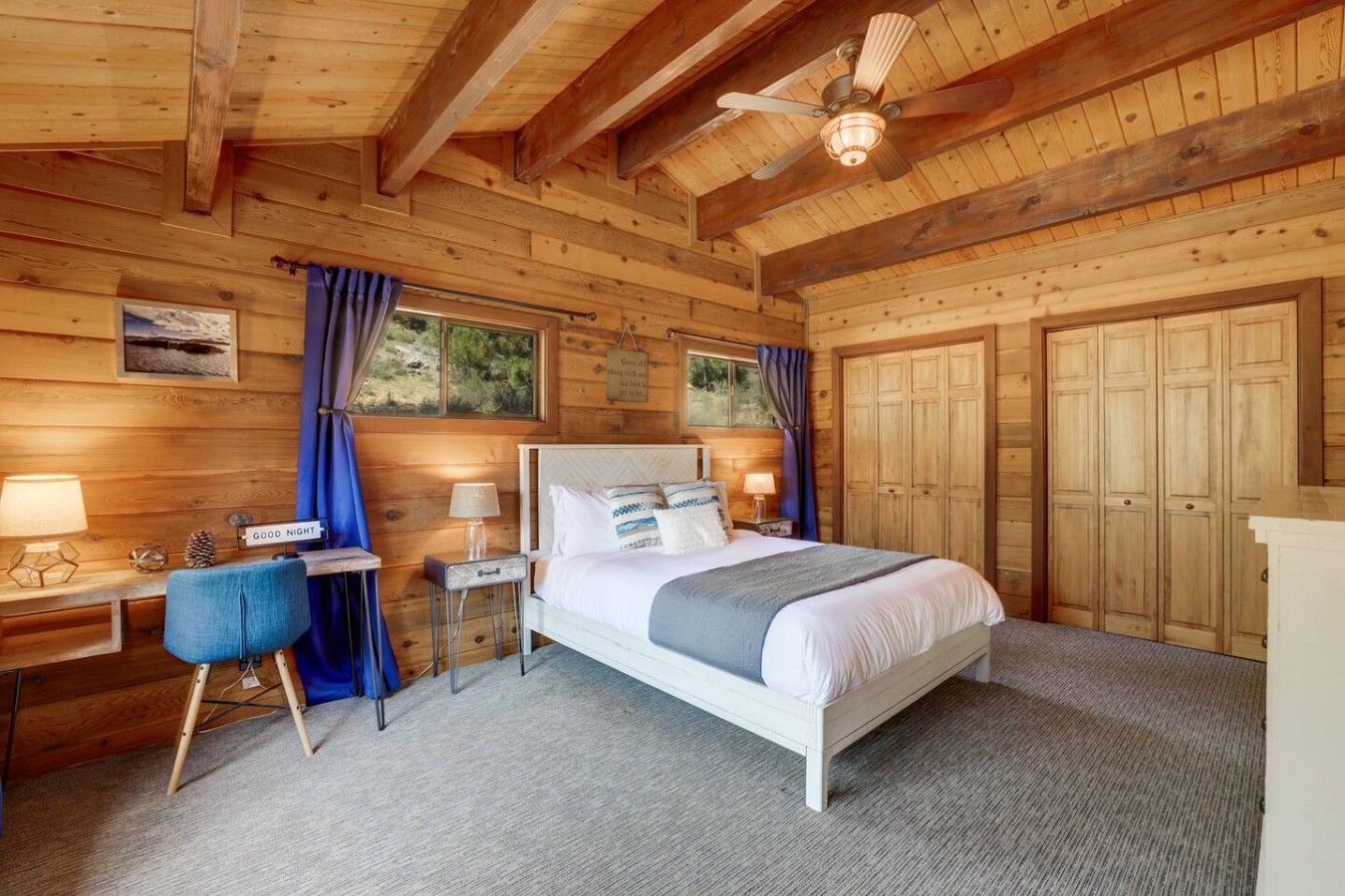 A wooden room with a bed, desk, and wardrobe.