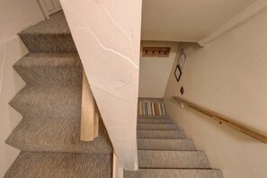 Eine Treppe mit Teppichstufen und einem Holnändergeländer.