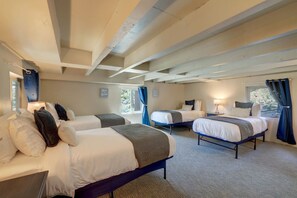 A hotel room with two beds, a desk, and a window with curtains.