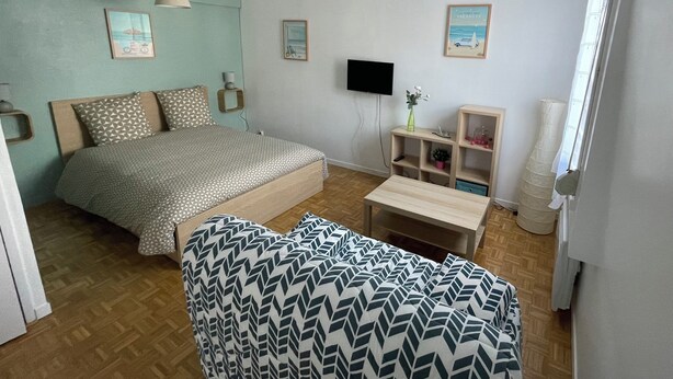 Ein Schlafzimmer mit Bett, Nachttischen, Fernseher, Schreibtisch und Stuhl.