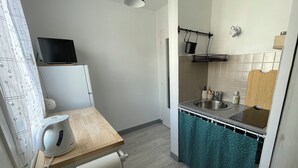 Eine kleine Küche mit Spüle, Wasserkocher und einer kompakten Arbeitsfläche.