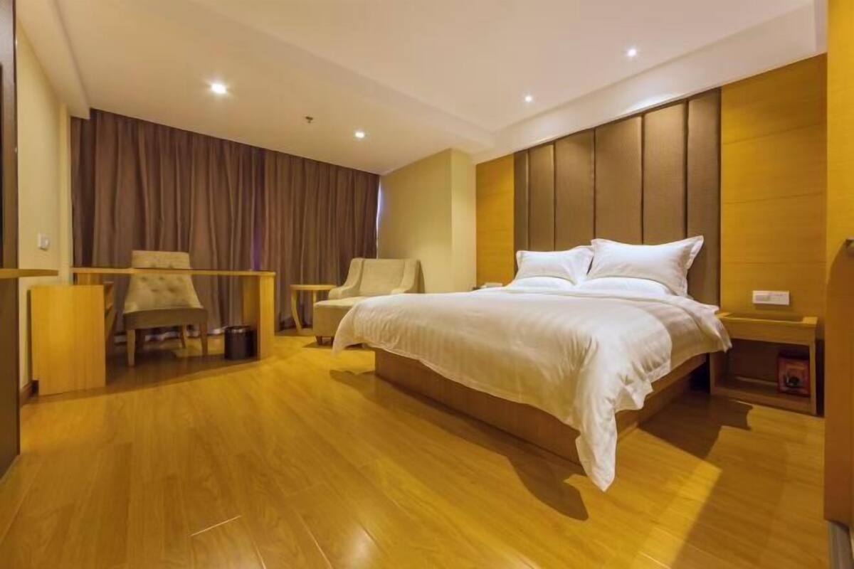 Una habitación de hotel moderna con una cama grande, un escritorio y una silla.