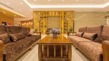 A modern living room with a sofa set, a wooden coffee table, and a decorative wall with bookshelves.