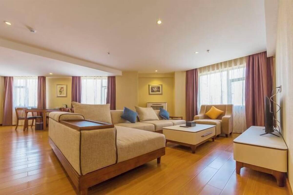 Un salón amplio con un conjunto de sofás, una mesa de centro y un televisor.