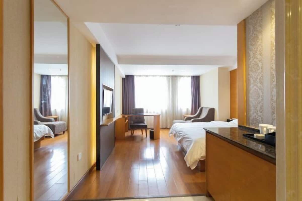 Una habitación de hotel con una cama, un escritorio, una silla y una mesita.