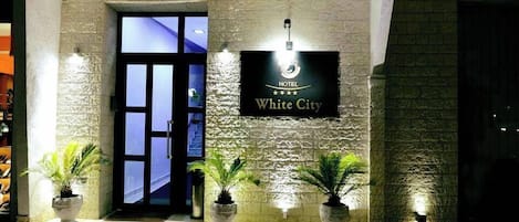 Ein Hotel Eingang mit einem Schild, auf dem 'HOTEL White City' steht.