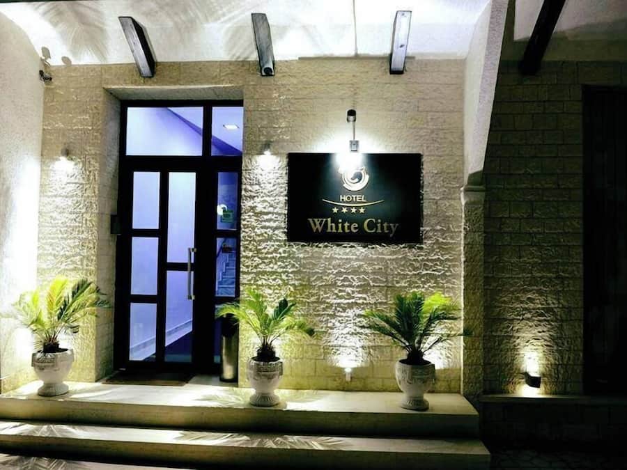 Entrada de hotel con un cartel que dice "HOTEL White City".