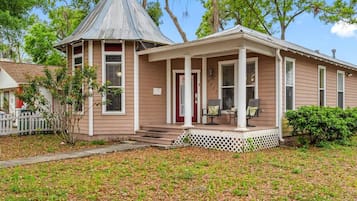 Une maison à deux étages avec un porche à l’avant, un petit garage attenant et une entrée avant abritée.