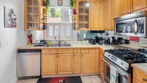 A modern kitchen with wooden cabinets, stainless steel appliances, and a built-in dishwasher.
