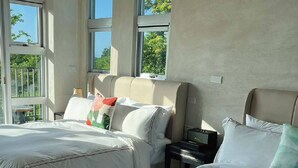 A hotel room with two beds, large windows, and a view of greenery outside. - 57villa (Hengchun)