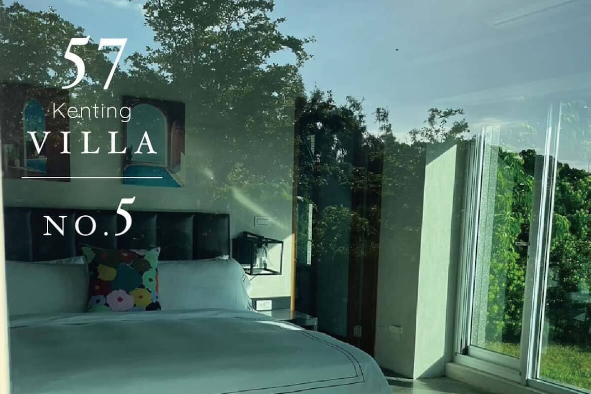 Un dormitorio moderno con una cama grande, una mesita de noche y un ventanal con vistas a zonas verdes.