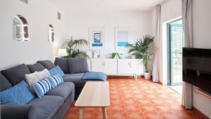 Ein modernes Wohnzimmer mit einem grauen Sofa, einem Holztisch und einer TV-Konsole.