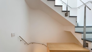A modern staircase with a wooden platform and metal railings. - Dimora Storica Torre Matta  – Elegance, history and sea views in the heart of Otr (Otranto)