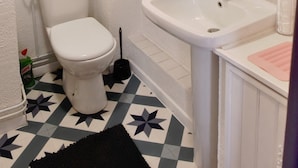 Un bagno con il water, un lavandino e uno specchio.