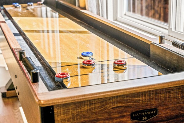 A pool table with a wooden frame and a glass top, featuring a logo on the side.