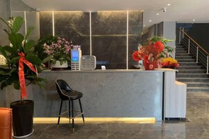 Una recepción de diseño moderno, una escalera y plantas en macetas.