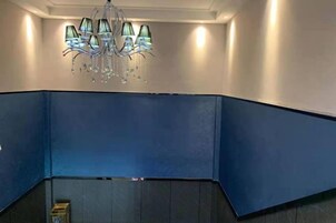 Una esquina con pared azul y una lámpara de araña.