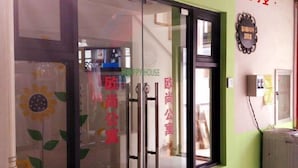 A hotel entrance with a glass door, a sign reading "HAPPY HOUSE," and a wall-mounted plaque. - Oushang Apartment (Shanghai)