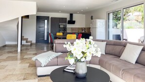 Een moderne woonkamer met een bank, salontafel en een bloevas.